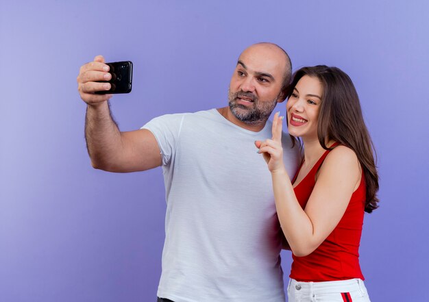 Gelukkig volwassen paar dat selfie vrouw doet vredesteken