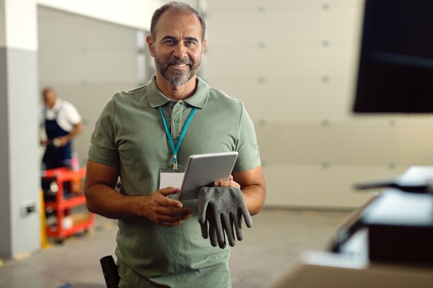 Gelukkig voorman van automonteur werkplaats met behulp van touchpad en camera kijken