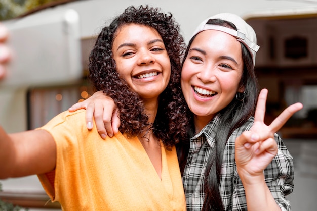 Gratis foto gelukkig vriendinnen vredessymbool