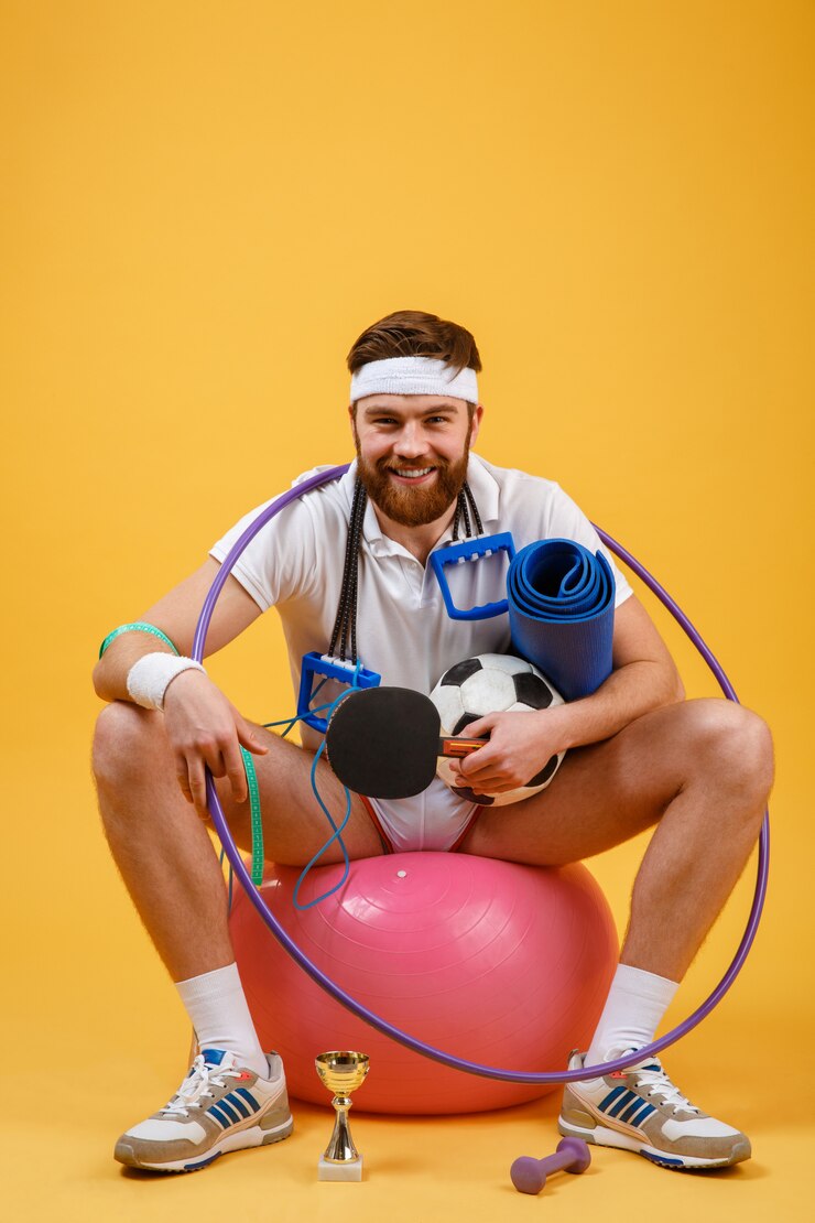 Gratis Foto gelukkig vrolijke fitness man zittend op een sport-bal