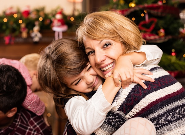 Gelukkig vrouw knuffelen haar dochtertje op Kerstmis