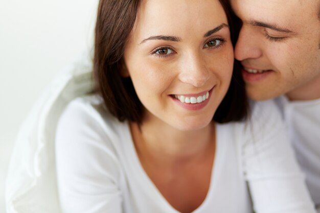 Gelukkig vrouw met haar vriend in bed