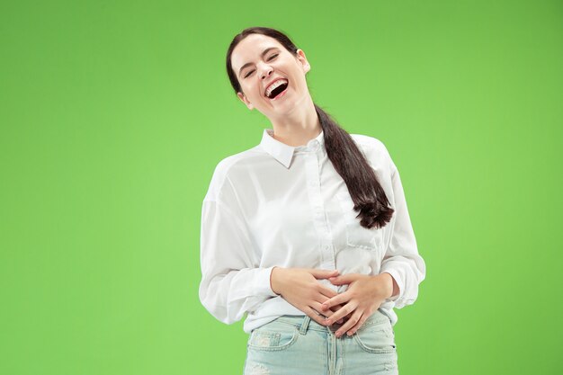 Gelukkig zaken vrouw permanent en glimlachend geïsoleerd op groene studio