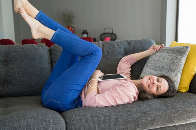 Gelukkige aantrekkelijke jonge vrouw die aan muziek luistert