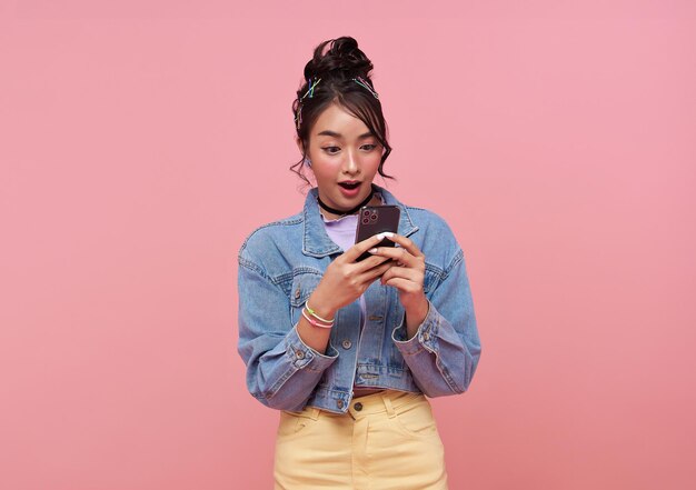 Gelukkige Aziatische portret mooie schattige jonge vrouw tiener glimlachend opgewonden met behulp van een slimme mobiele telefoon