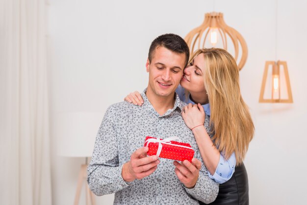 Gelukkige dame die jonge kerel met heden omhelst