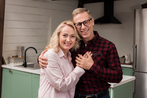 Gelukkige en ouders die omhelzen glimlachen stellen