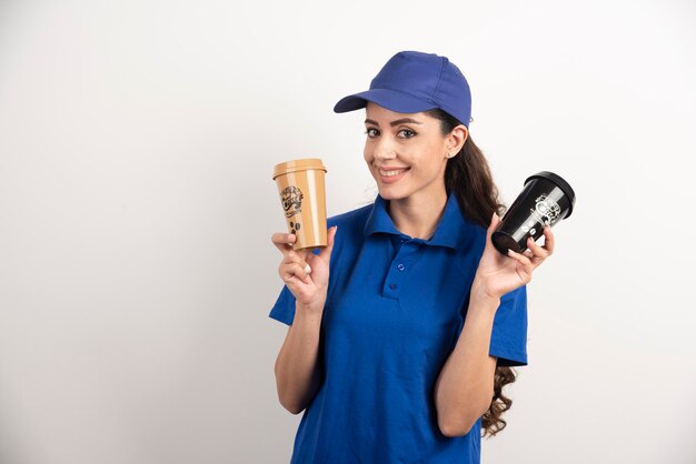 Gelukkige en positieve bezorger met kopjes koffie. Hoge kwaliteit foto