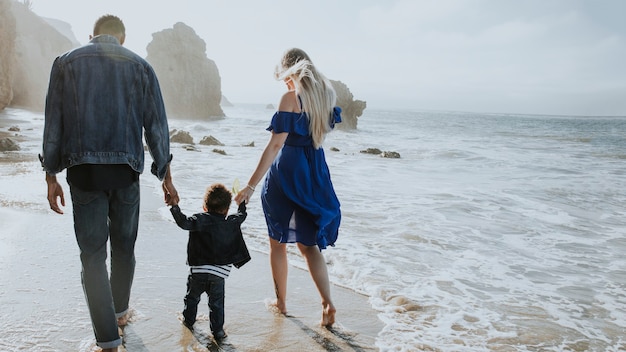 Gelukkige familie die samen op het strand loopt