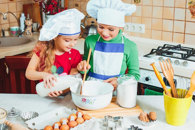 Gratis foto gelukkige familie grappige kinderen bereiden het deeg voor, bakken koekjes in de keuken