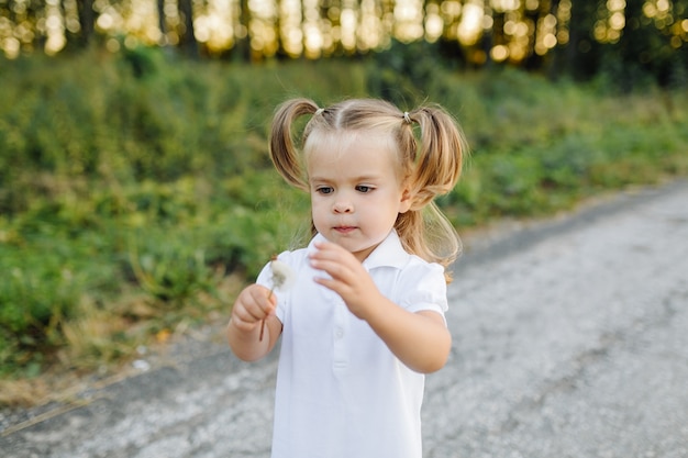 Gratis foto gelukkige familie in een park in de zomer de herfst. moeder, vader en baby spelen in de natuur in de stralen van de zonsondergang