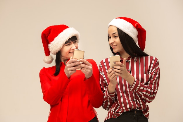 Gelukkige familie in kerstmissweater poseren met mobiele telefoons.