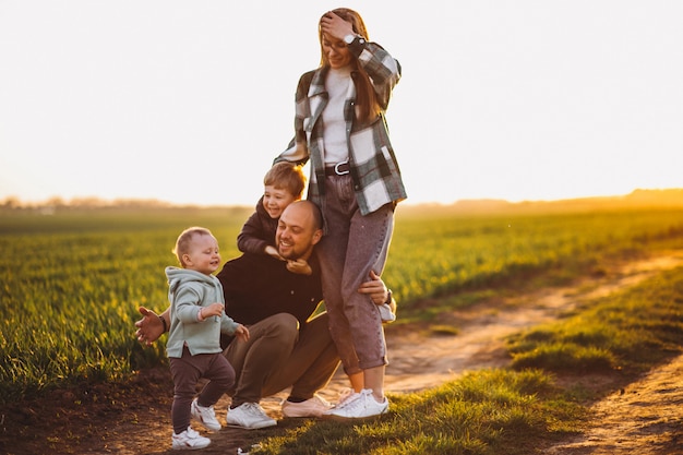 Gelukkige familie plezier in het veld op de zonsondergang