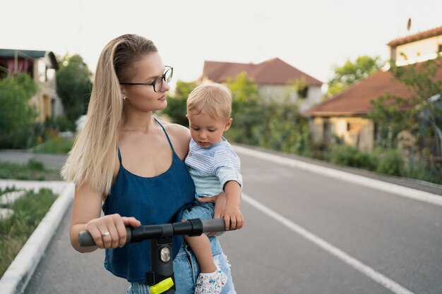 Gelukkige familie rijden scooter in de buurt op de weg.