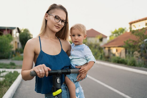 Gelukkige familie rijden scooter in de buurt op de weg.