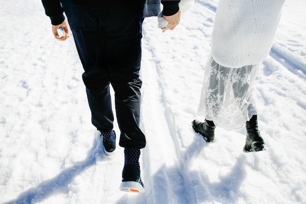 Gelukkige geliefden lopen samen in de sneeuw
