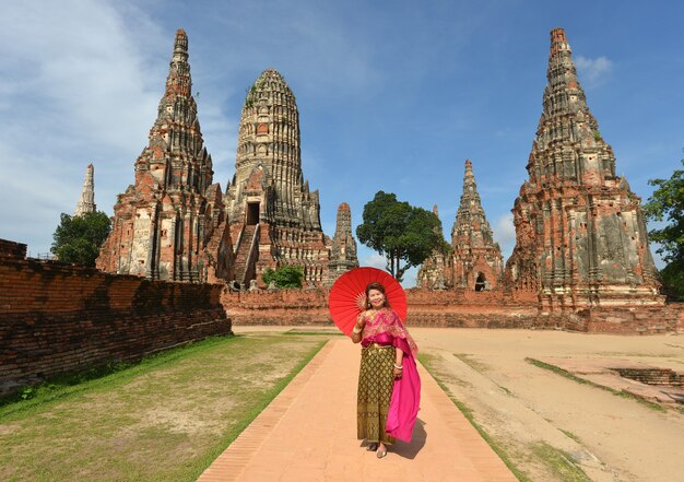 Gelukkige gepensioneerde vrouw in de traditionele Thaise jurk reizen in de tempel.