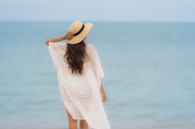 Gelukkige glimlach van de portret ontspant de mooie jonge Aziatische vrouw op de strand overzeese oceaan