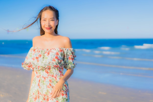 Gelukkige glimlach van de portret ontspant de mooie jonge Aziatische vrouw rond tropische strand overzeese oceaan