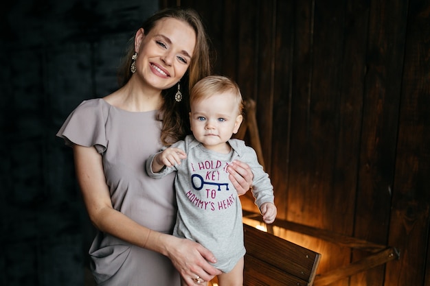 Gratis foto gelukkige glimlachende familie bij studio op achtergrond van de kerstboom met gift