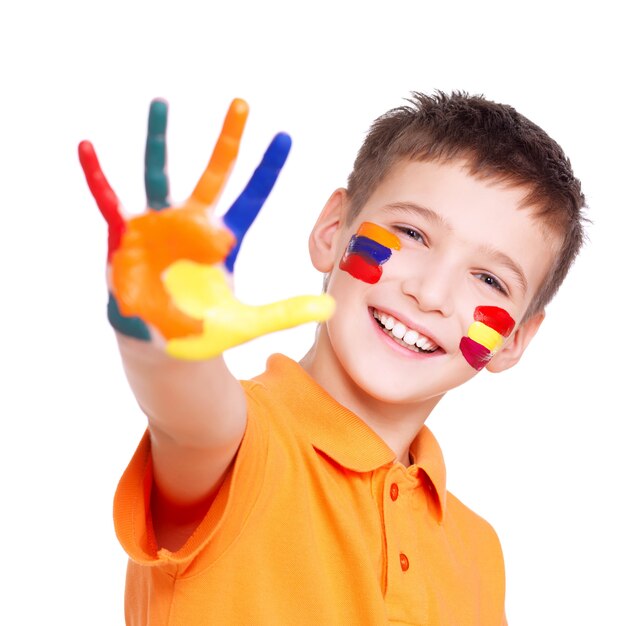 Gelukkige glimlachende jongen met een geschilderde hand en gezicht in oranje t-shirt op wit.