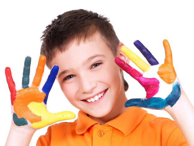 Gelukkige glimlachende jongen met geschilderde die handen - op wit wordt geïsoleerd.