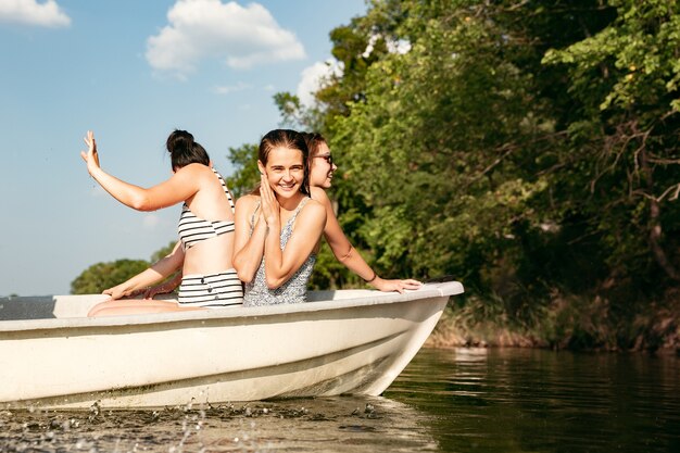 Gelukkige groep vrienden die plezier hebben tijdens het lachen, opspattend water en zwemmen in de rivier