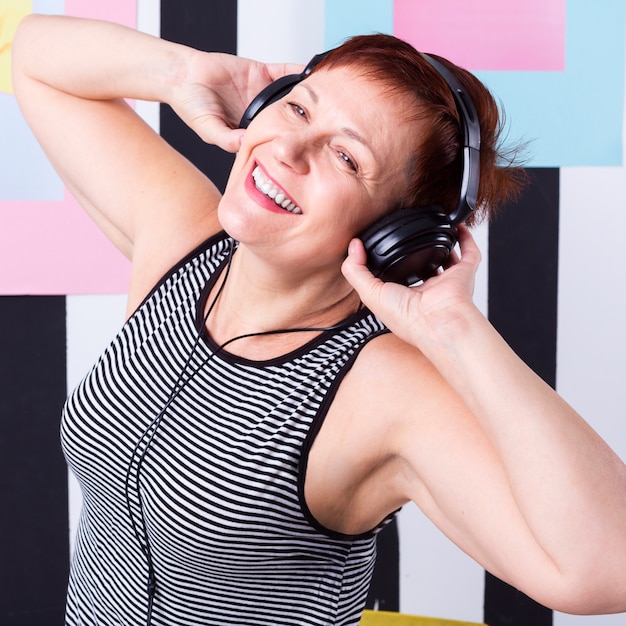 Gratis foto gelukkige hogere vrouw het luisteren muziek
