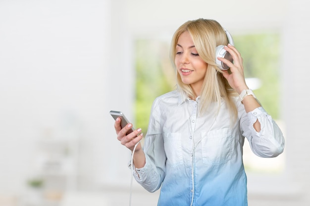 Gelukkige jonge blonde vrouw die naar muziek luistert