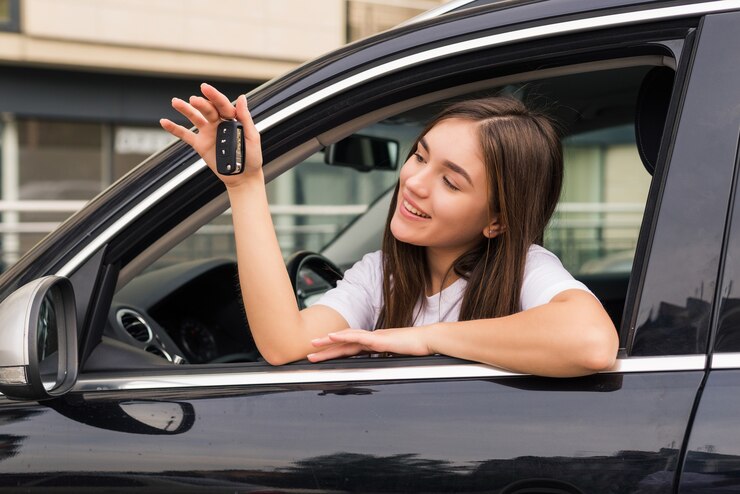 Gelukkige jonge glimlachende vrouw met nieuwe autosleutel