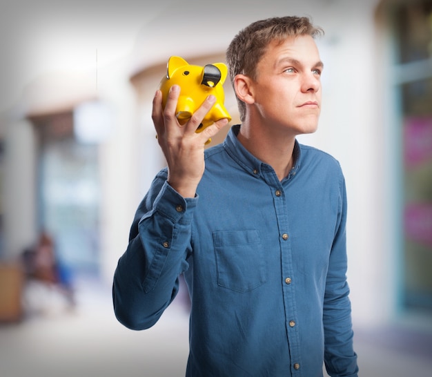 Gratis foto gelukkige jonge man met een piggy-bank