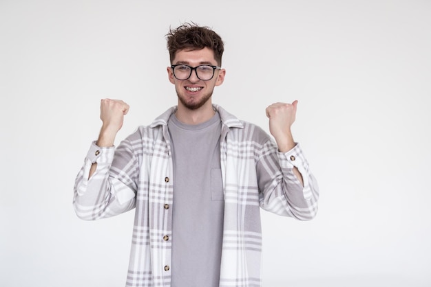 Gratis foto gelukkige jonge man wint op witte achtergrond