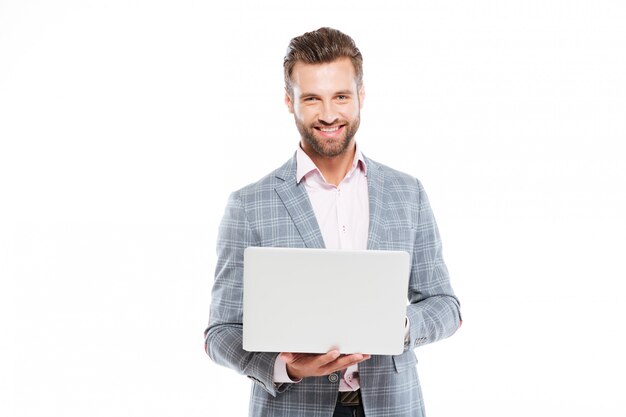 Gelukkige jonge mens die laptop computer met behulp van