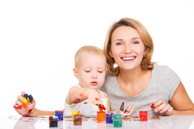 Gelukkige jonge moeder met een babyverf door handen - die op wit wordt geïsoleerd.