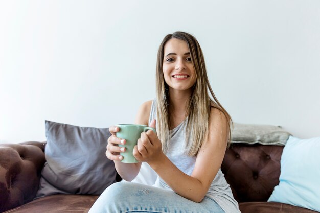 Gelukkige jonge vrouw die een koffie heeft