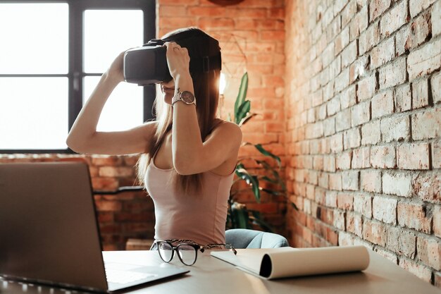 Gelukkige jonge vrouw met VR-hoofdtelefoon. Thuis spelen