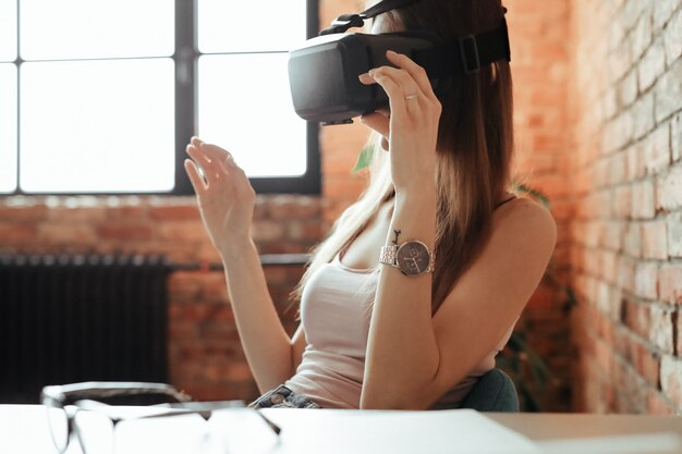 Gelukkige jonge vrouw met VR-hoofdtelefoon. Thuis spelen