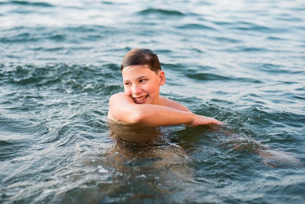 Gelukkige jongen die in de zee zwemt