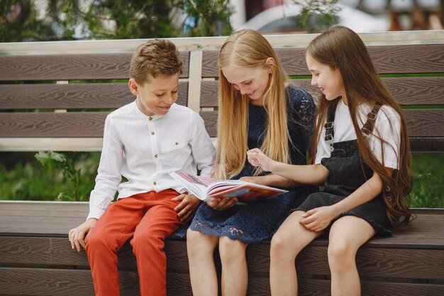 Gelukkige kinderen die dicht bij elkaar zitten en glimlachen