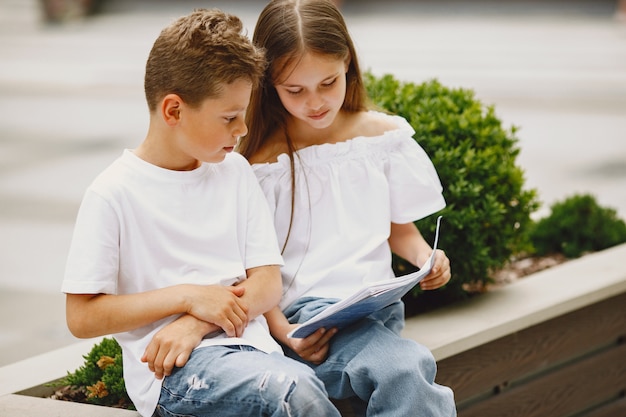 Gelukkige kinderen die dicht bij elkaar zitten en glimlachen