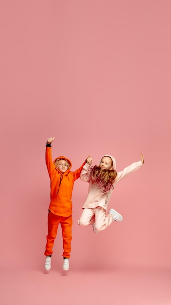 Gelukkige kinderen geïsoleerd op koraal roze studio achtergrond Kijk gelukkig vrolijk oprecht Copyspace Jeugd onderwijs emoties concept
