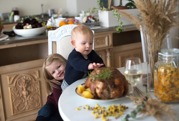 Gelukkige kinderen - klein meisje en babyjongen thuis keuken aan tafel