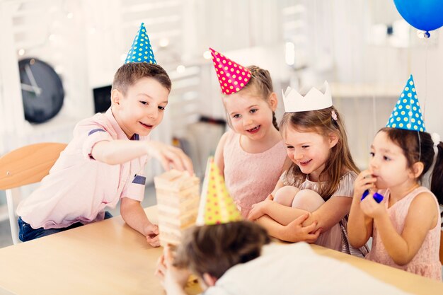 Gelukkige kinderen spelen spel aan tafel