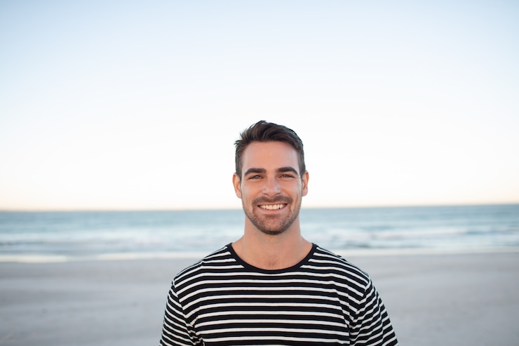 Gratis Foto gelukkige man die op het strand staat.