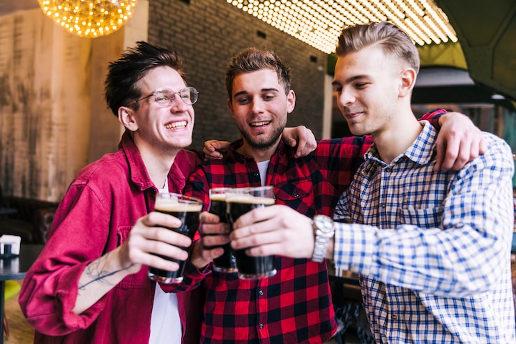 Gratis Foto gelukkige mannelijke vriend die cheers met bierglazen maken