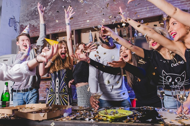 Gelukkige mannen en vrouwen die confetti gooien