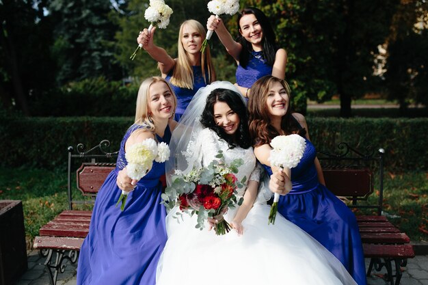 Gelukkige meiden met bruid op bankje
