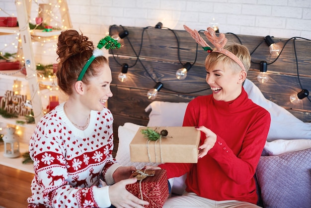 Gelukkige meisjes die Kerstmis in bed vieren