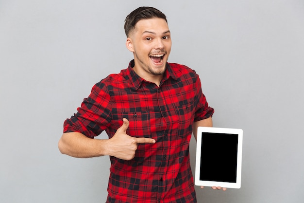 Gelukkige mens die het lege scherm van de tabletcomputer toont
