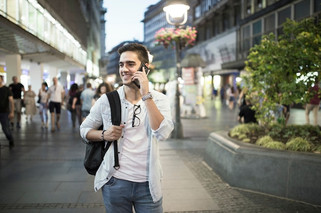 Gelukkige mens die op smartphone spreekt